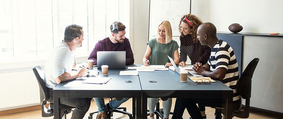 Group of diverse employees working together at a desk.