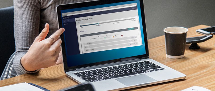 Woman pointing to fraud management AI, ARIA on laptop.