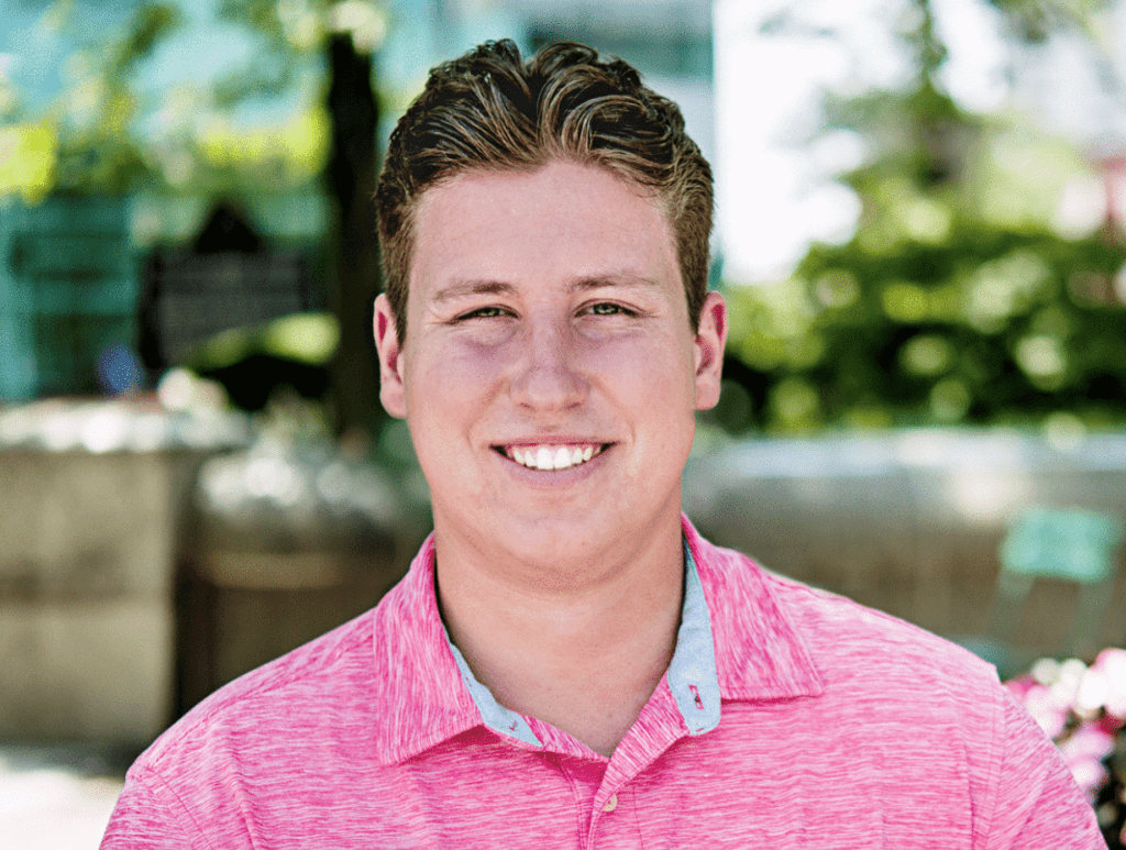 Young man in a pink polo with blond hair.